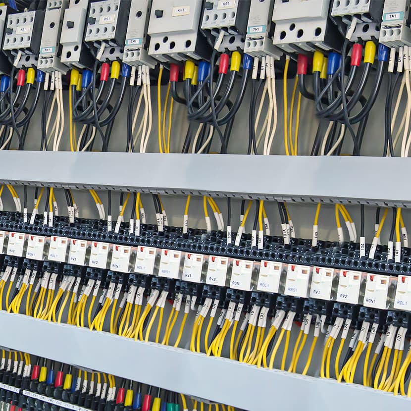 Industrial electrical control panel with circuit breakers, labeled wiring, and terminal blocks for power distribution