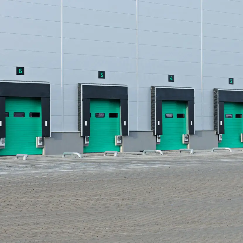Commercial building facade with multiple green industrial doors for tenant submetering applications